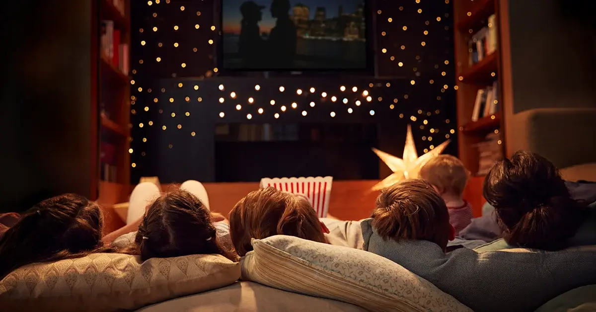 An image of a family laying together watching a movie.